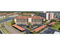 Stunning aerial view of the condo building featuring covered parking and lovely landscaping near the water at 19029 Us Highway 19 N # 26-204, Clearwater, FL 33764