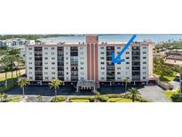 Condominium building featuring multiple floors, balconies, and water views at 19029 Us Highway 19 N # 9-407, Clearwater, FL 33764