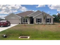 Charming home with a well-manicured lawn and a two-car garage, offering curb appeal and convenience at 26357 Trinilas Dr, Punta Gorda, FL 33983