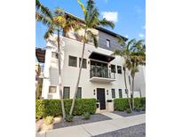 Contemporary three-story home with modern design, clean lines, balcony, and landscaped yard with mature palm trees at 325 2Nd N St, St Petersburg, FL 33701
