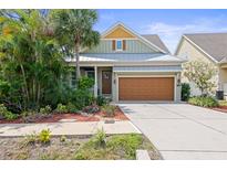 Charming single-Gathering home with a well-manicured lawn, lush landscaping, and attached two-car garage at 7615 S Fitzgerald St, Tampa, FL 33616