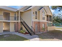 Inviting condo complex exterior featuring brick accents, well-maintained landscaping, and convenient staircase access at 8724 Mallard Reserve Dr # 101, Tampa, FL 33614
