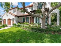 Charming two-story home with white stucco, a red tile roof, and a well-manicured lawn at 90 Bahama Cir, Tampa, FL 33606