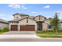 Stunning two-story home featuring a stone facade, three-car garage, and manicured front lawn at 11146 Rustic Timber Loop, San Antonio, FL 33576