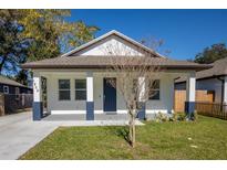 Charming renovated home with a manicured lawn and inviting front porch, showcasing curb appeal at 1808 E Comanche Ave, Tampa, FL 33610