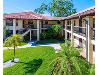 Inviting condo exterior with lush landscaping, red tile roof, and multiple floors of units at 2213 Hammock Pine Blvd, Clearwater, FL 33761