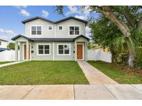 Charming two-story home with green grass, walkway and tidy landscaping on a sunny day at 3455 17Th S Ave, St Petersburg, FL 33711
