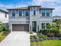 Charming two-story home with a well-manicured lawn and beautiful landscaping at 5601 Limelight Dr, Apollo Beach, FL 33572