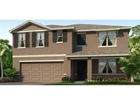 Two story home featuring stucco siding, a covered entryway, 2-car garage, and tropical landscaping at 1421 Brown Mallet Pl, Ruskin, FL 33570