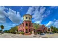 Charming red brick commercial building with a yellow tower, palm trees, and beautiful blue sky at 1810 E Palm Ave # 5114, Tampa, FL 33605