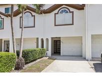Inviting townhouse with a well-maintained front exterior, driveway, and attached garage for convenient parking and easy access at 269 Madeira Cir, Tierra Verde, FL 33715