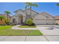 Charming single-story home featuring a lush front yard and a three-car garage at 7001 Cohasset Cir, Riverview, FL 33578