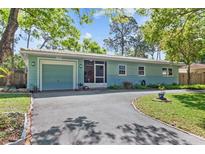 Charming single-story home with blue siding, a well-manicured front lawn, and a convenient circular driveway at 7747 90Th N Way, Seminole, FL 33777