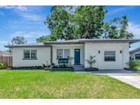 Charming single-story home featuring a well-manicured lawn and a freshly painted exterior with a bright blue front door at 1545 Illinois Rd, Clearwater, FL 33756