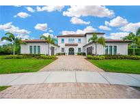 Stately two-story home with lush landscaping, a paver driveway, and a tile roof at 16419 Chapman Crossing Dr, Lithia, FL 33547