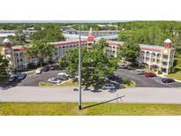 Aerial view of multi-story building, parking lot, and surrounding landscaped grounds at 2430 Florentine Way # 46, Clearwater, FL 33763