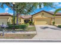 Charming single-Gathering home featuring a tile roof, two-car garage, and meticulously landscaped front yard at 305 Bluewater Falls Ct, Apollo Beach, FL 33572