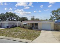 Charming single-story home with an attached garage and well-maintained landscaping at 3514 Truman Dr, Holiday, FL 34691