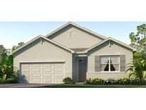 Charming single-story home featuring a two-car garage and landscaped front yard at 35687 Lockman Way, Zephyrhills, FL 33541