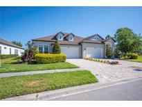 Stunning home exterior with a paved driveway, well-manicured lawn, and a three car garage at 4405 Barletta Ct, Wesley Chapel, FL 33543