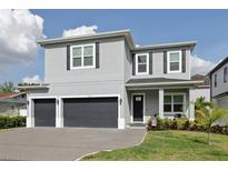 Beautiful two-story home with a two-car garage, dark shutters and well-manicured landscaping at 714 S Lois Ave, Tampa, FL 33609