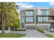 Modern townhome with large windows, a two-car garage and a professionally landscaped front yard at 98 W Davis Blvd, Tampa, FL 33606