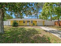 Charming yellow single-story home with a well-manicured front yard and inviting entrance at 1019 Goshen Rd, Tarpon Springs, FL 34689