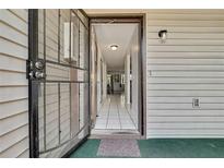 View of the doorway leading into the home with tiled flooring and a storm door at 12155 Environmental Dr # 3, New Port Richey, FL 34654