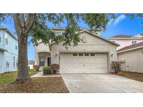 Charming two-story home features a well-maintained lawn and an attached two-car garage at 12508 Evington Point Dr, Riverview, FL 33579