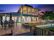 Beautiful backyard featuring a pool, spa, outdoor dining, spiral staircase, and a covered balcony overlooking the waterfront at 139 Wall St, Redington Shores, FL 33708