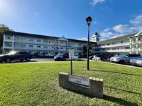 Exterior view of American Gothic, a multi-story condo complex with manicured lawn at 2469 Franciscan Dr # 53, Clearwater, FL 33763