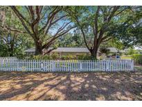 Charming single-story home featuring a white picket fence and mature trees at 34651 Appaloosa Trl, Zephyrhills, FL 33541