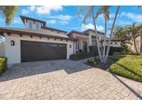 Stunning two-story home with a 2-car garage and a beautifully paved driveway lined with lush tropical landscaping at 597 Bay St, Palm Harbor, FL 34683