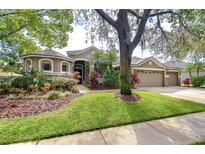 Charming single-Gathering home showcasing a well-manicured lawn and lovely landscaping with a three car garage at 6112 Ibispark Dr, Lithia, FL 33547