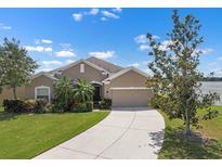 Charming single-story home featuring a well-manicured lawn, mature landscaping, and a two-car garage at 626 15Th Nw Ave, Ruskin, FL 33570