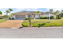 Charming one-story home featuring a tile roof, manicured lawn, and a two-car garage at 6994 Country Lakes Cir, Sarasota, FL 34243