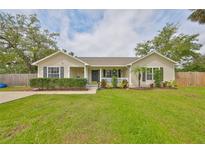 Charming home with a manicured lawn, trimmed hedges, black shutters, and inviting front porch at 8805 Van Fleet Rd, Riverview, FL 33578