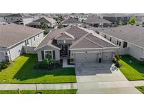 Charming single-story home featuring a three-car garage and meticulously manicured landscaping at 10978 Laxer Cay Loop, San Antonio, FL 33576