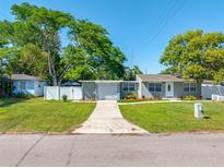 Charming single-story home with well-maintained lawn and a white picket fence at 1290 Bertland Way, Clearwater, FL 33755
