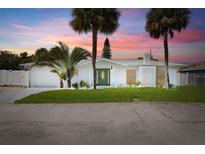 Charming single-story home with a well-manicured lawn, palm trees, and a decorative front door at 429 88Th Ave, St Pete Beach, FL 33706