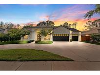 Beautiful home exterior with a three car garage, pristine lawn, and inviting curb appeal at sunset at 5605 Glencrest Blvd, Tampa, FL 33625