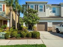 Charming two-story home with a well-maintained lawn, lush landscaping, and a two-car garage at 602 Cabernet Way, Oldsmar, FL 34677