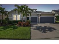 Charming single-story home with a well-manicured lawn, lush landscaping, and a spacious two-car garage at 6326 Waves End Pl, Apollo Beach, FL 33572