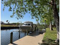 A boat rests on a lift attached to a private dock on the water at 6533 Channelside Dr, New Port Richey, FL 34652
