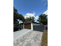 Charming single-story home featuring neutral paint, a brown garage door, and a stylish driveway at 2917 W Fern St, Tampa, FL 33612