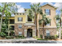 Attractive condo building with stone accents, palm trees, and a well-maintained landscape at 10103 Courtney Oaks Cir # 103, Tampa, FL 33619