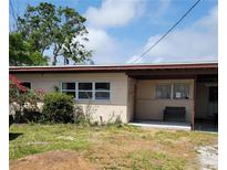 A single story home with a covered carport and front yard with mature landscaping at 10106 66Th Ave, Seminole, FL 33772