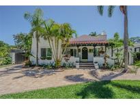 Charming single-Gathering home featuring lush landscaping, a terracotta roof, and a welcoming covered entry at 1175 Jackson Rd, Clearwater, FL 33755