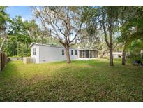 Large backyard with lush greenery, mature trees and screened-in porch at 12430 Oconee Blvd, New Port Richey, FL 34654