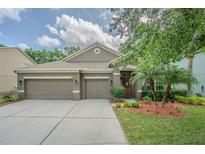 Charming single-story home with a three-car garage and beautifully landscaped front yard at 1418 Rushgrove Cir, Dover, FL 33527